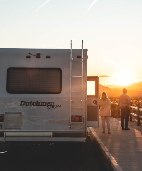 back of RV with two people staring at sunset
