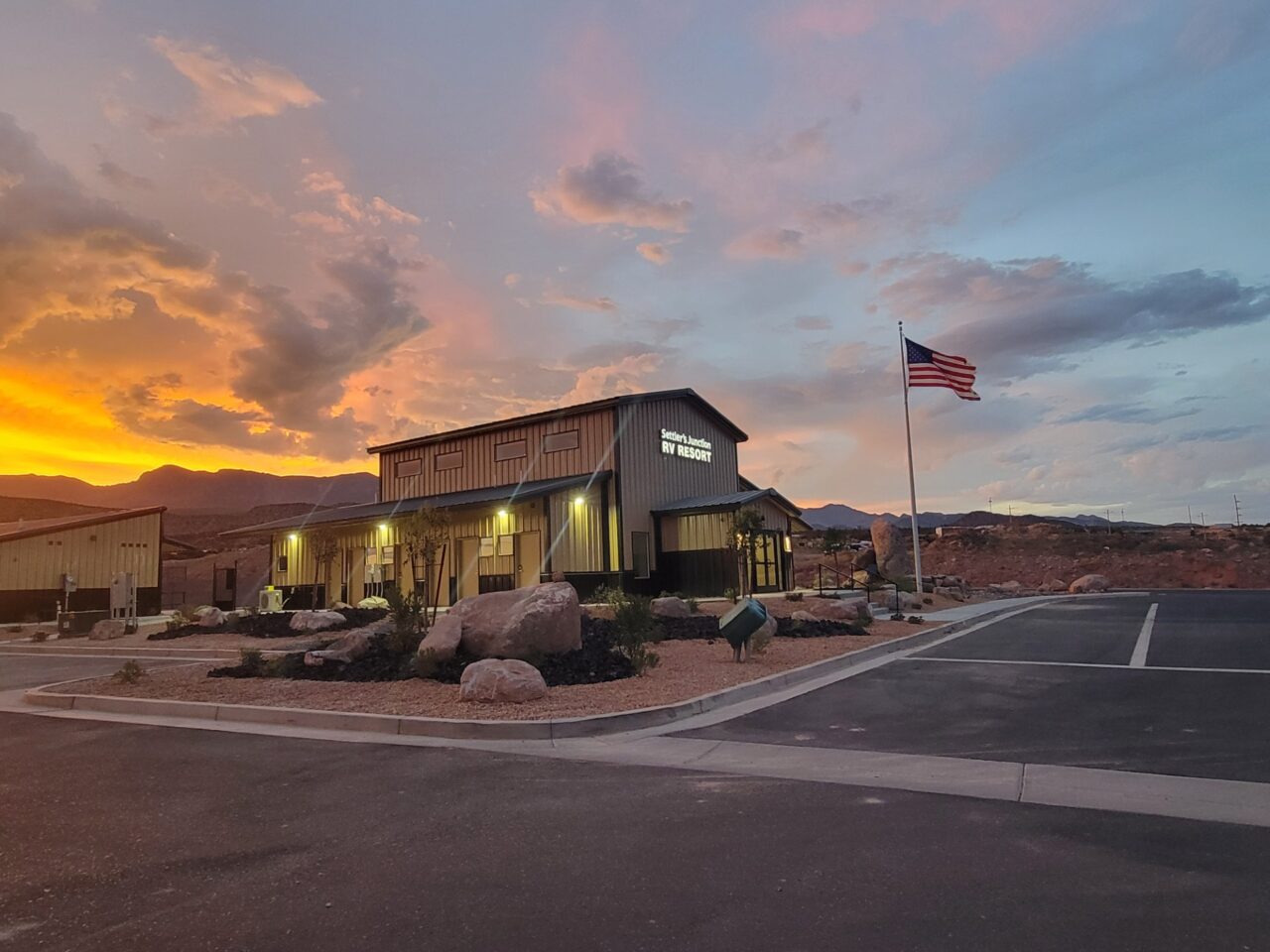 Settler’s Junction clubhouse and paved entrance at sunset