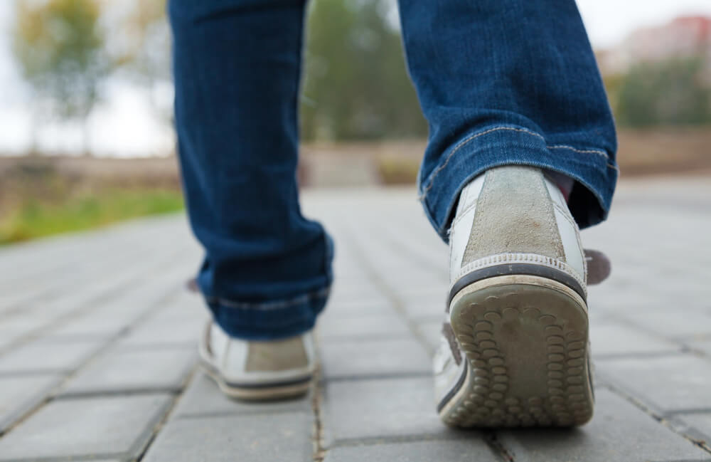 Close-up of a person walking on a stone path. The paths at the Brigham Young Winter Home site are easily walkable.
